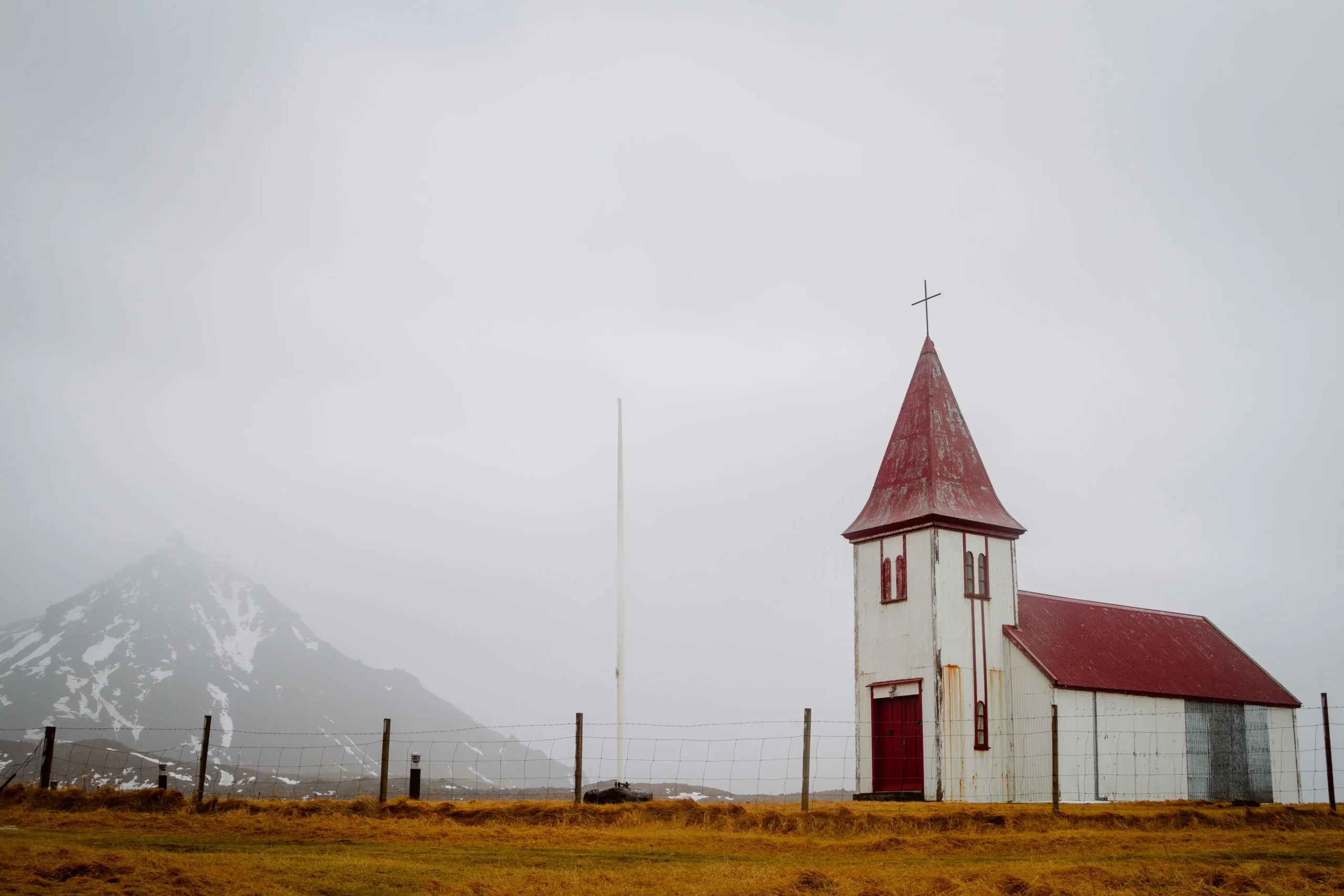 old-church-with-red-roof-field-cloudy-sky-iceland-min